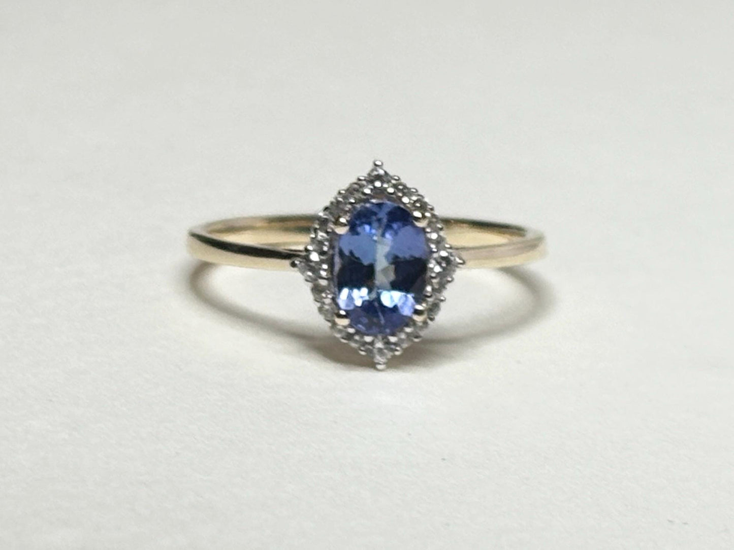 Oval tanzanite and zircon halo ring in solid 9k gold.