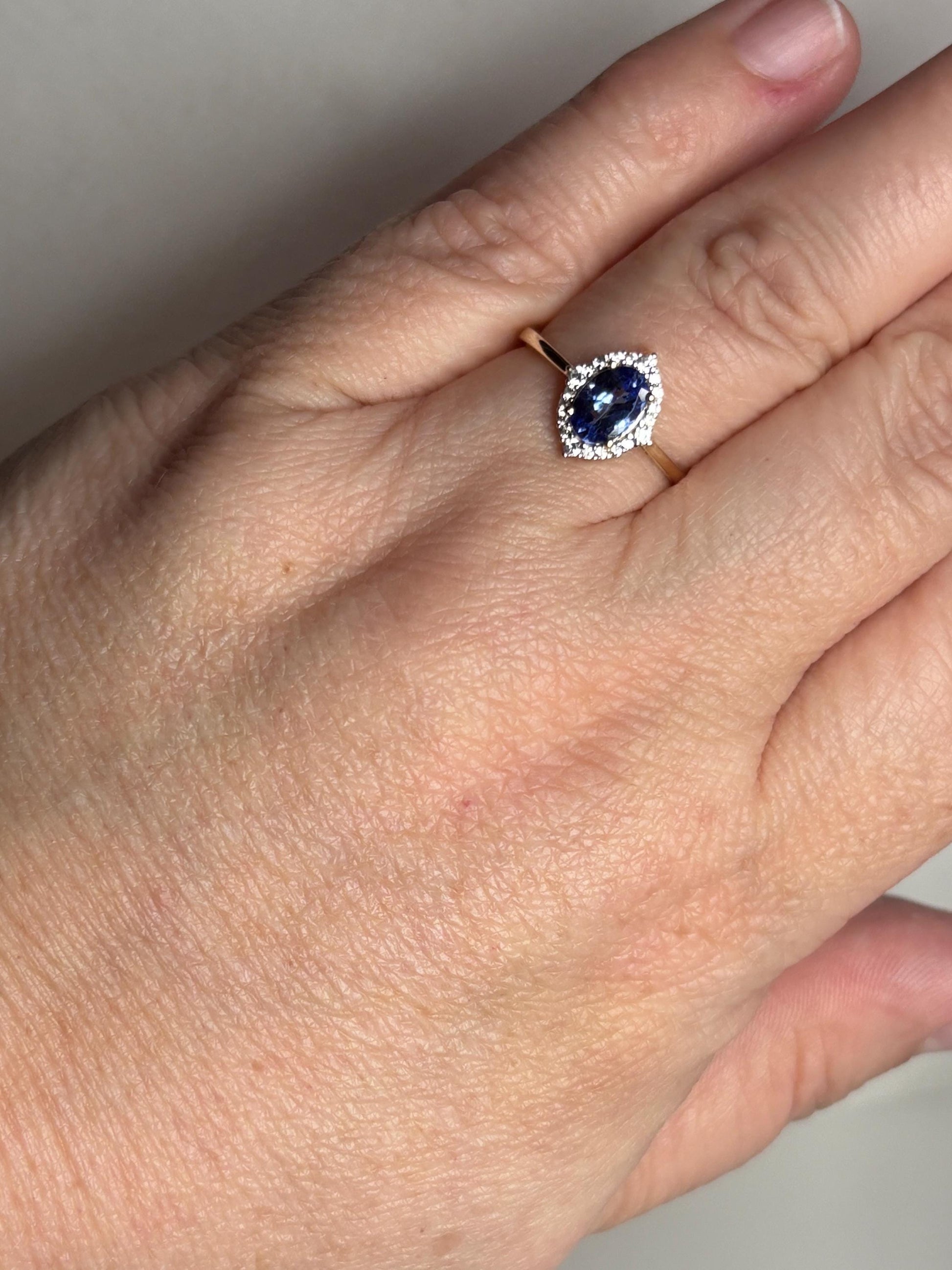 A 9k gold ring with a marquise-cut tanzanite surrounded by zircons.