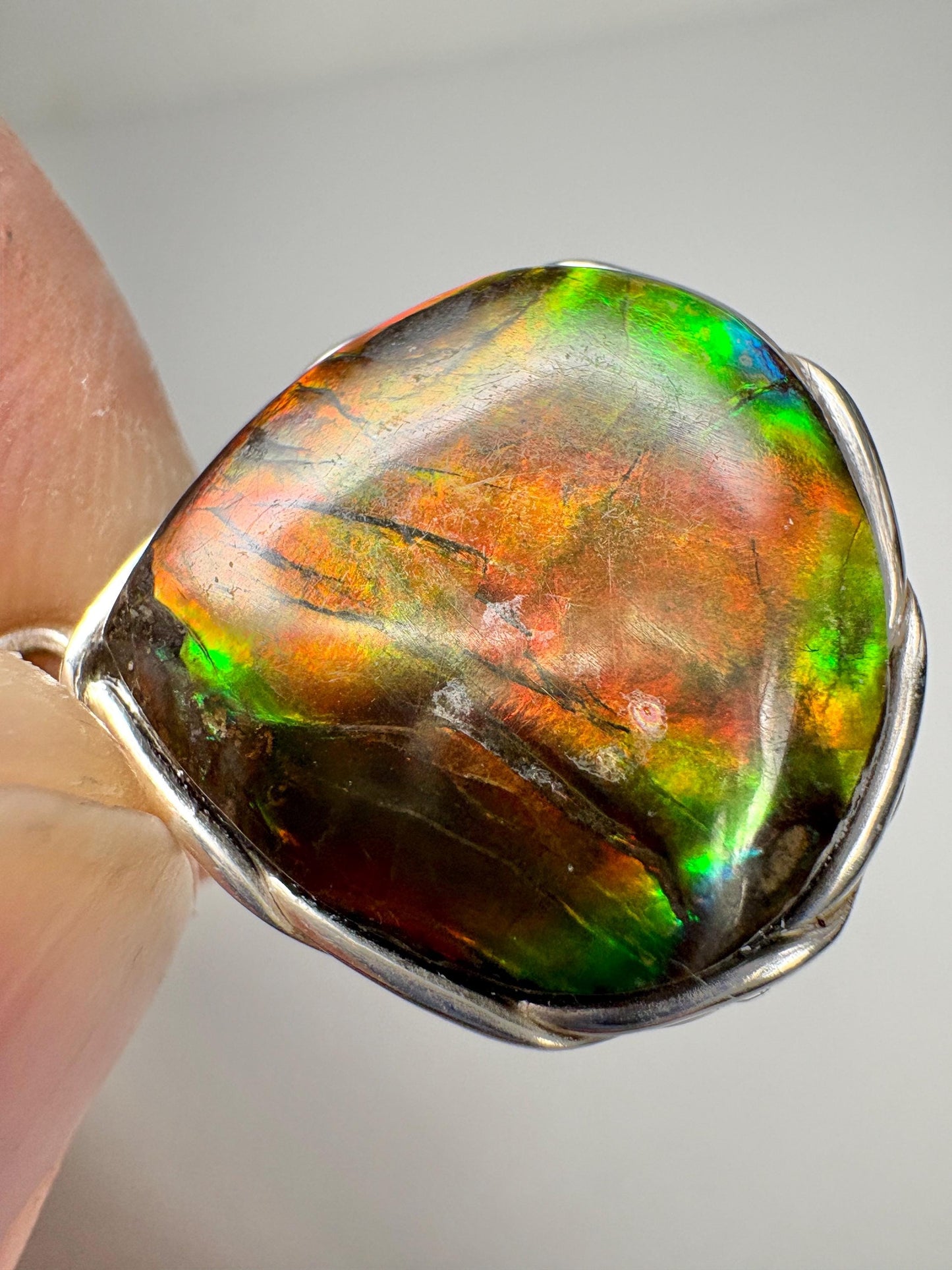 Natural ammolite pendant necklace in sterling silver with braided bezel.