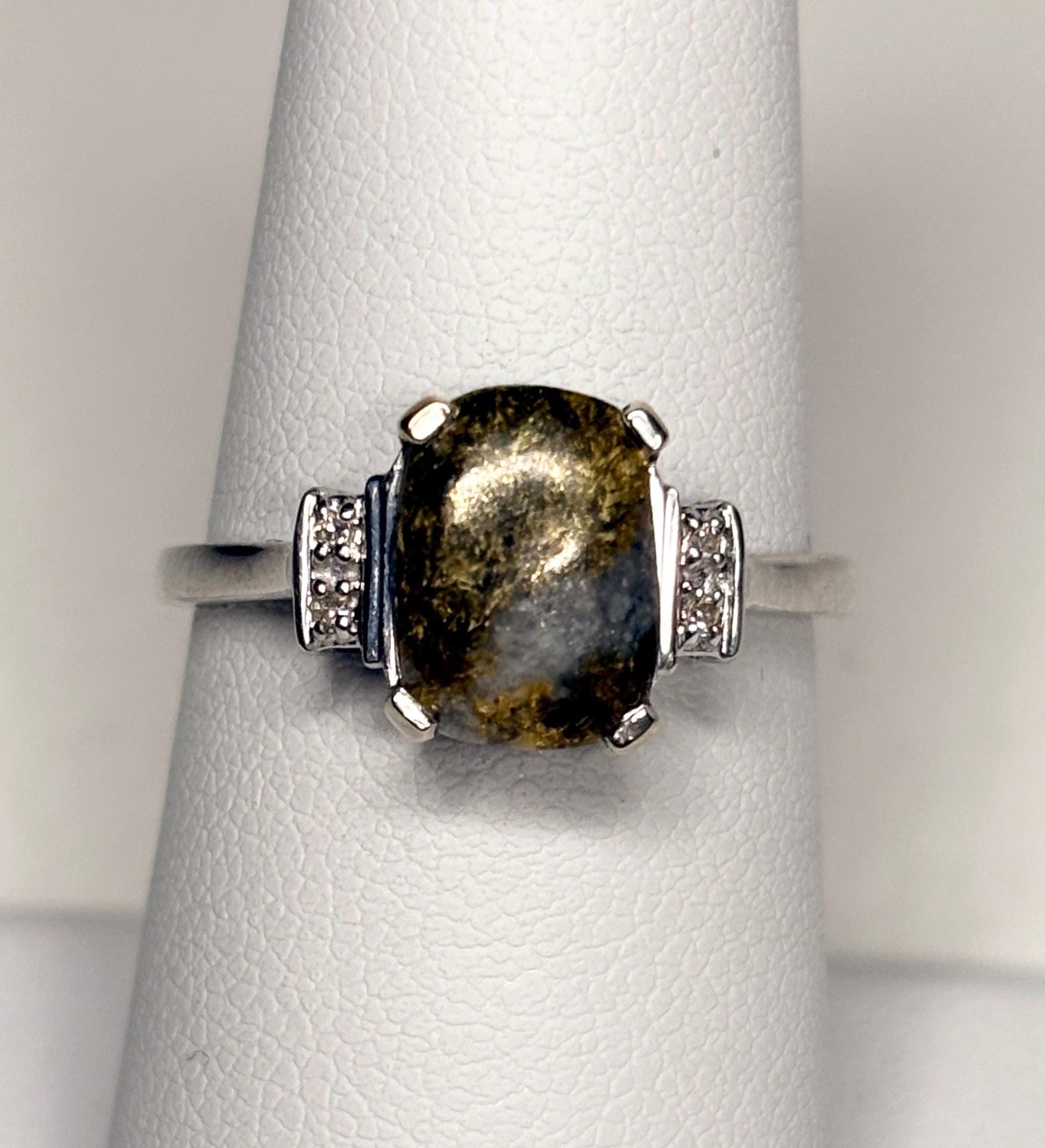 A 10k white gold ring with a cushion-shaped California gold in quartz stone and small diamonds.