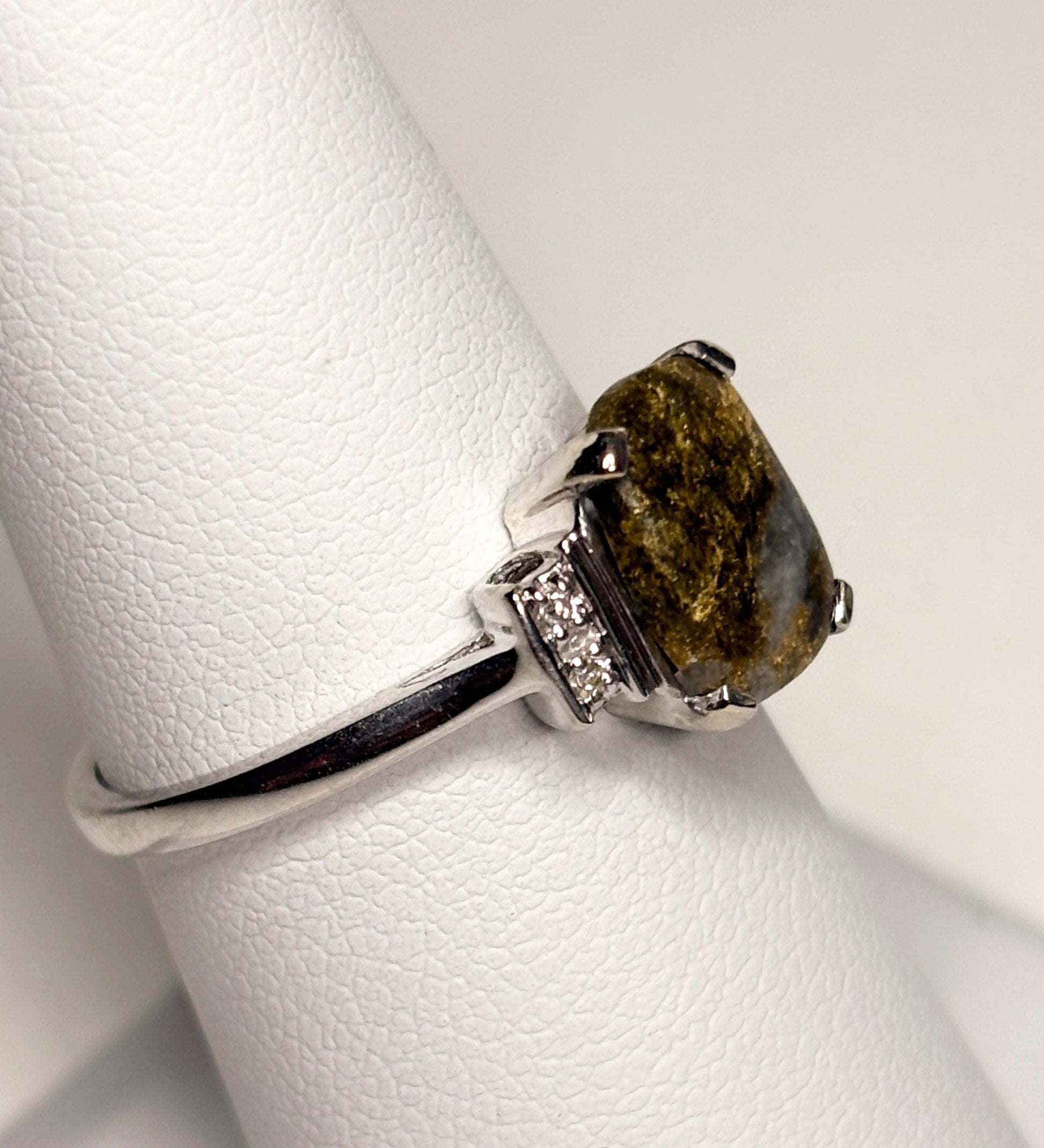 Ring with gold in quartz and diamonds on a white textured surface.