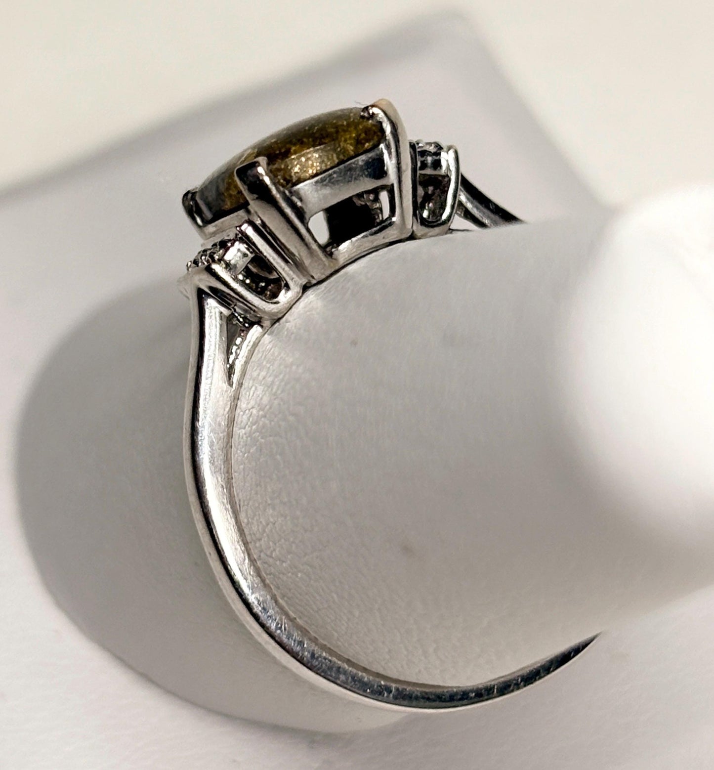 10k white gold ring with a cushion-cut gold in quartz center stone and small diamonds.