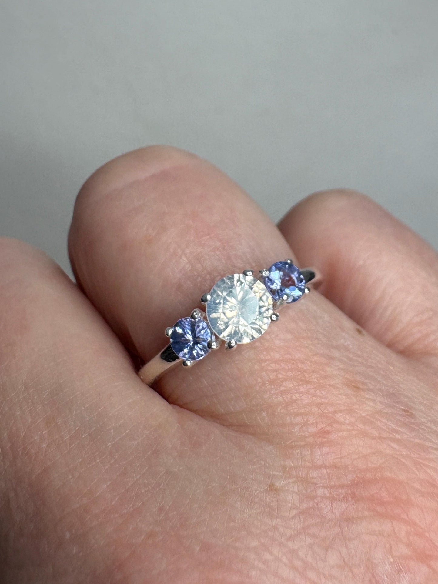 Sterling silver ring with a central off-white zircon and two tanzanite stones.