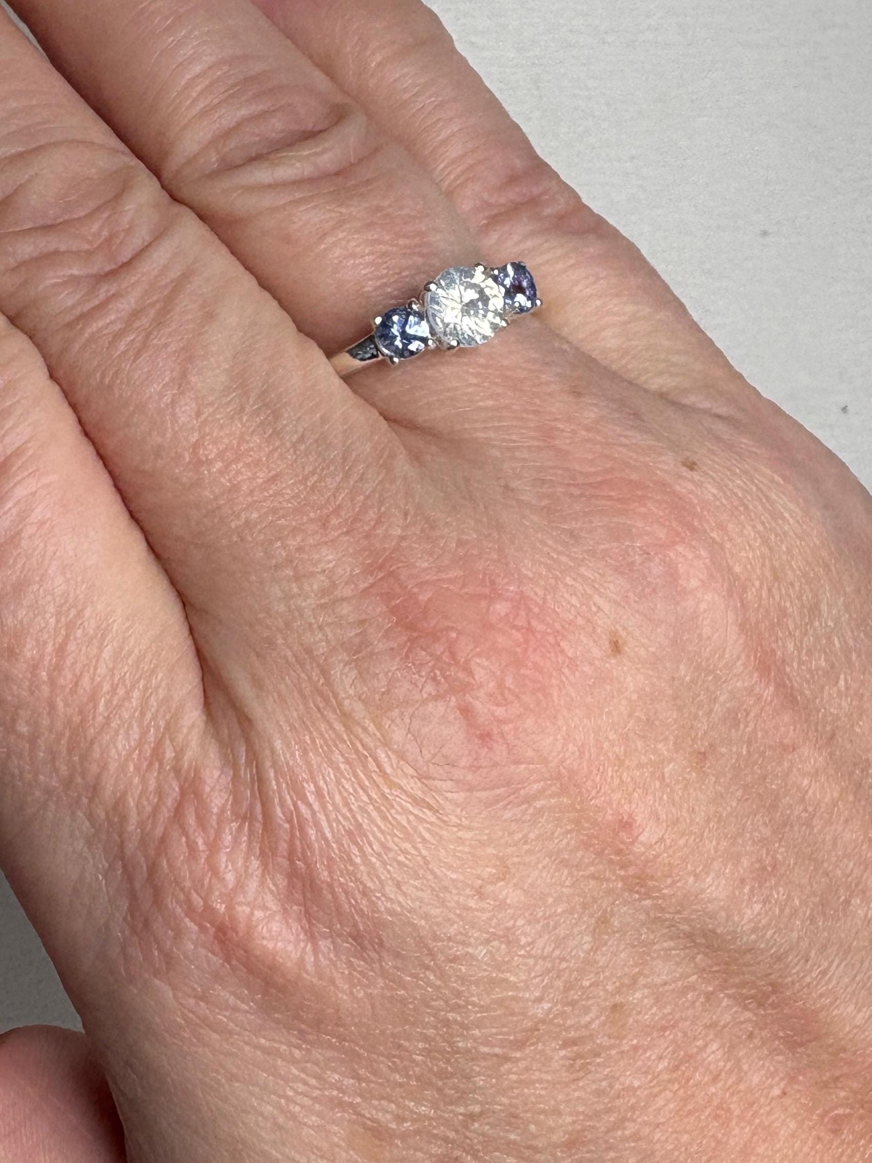 Sterling silver ring with a central off-white zircon and two tanzanite stones.