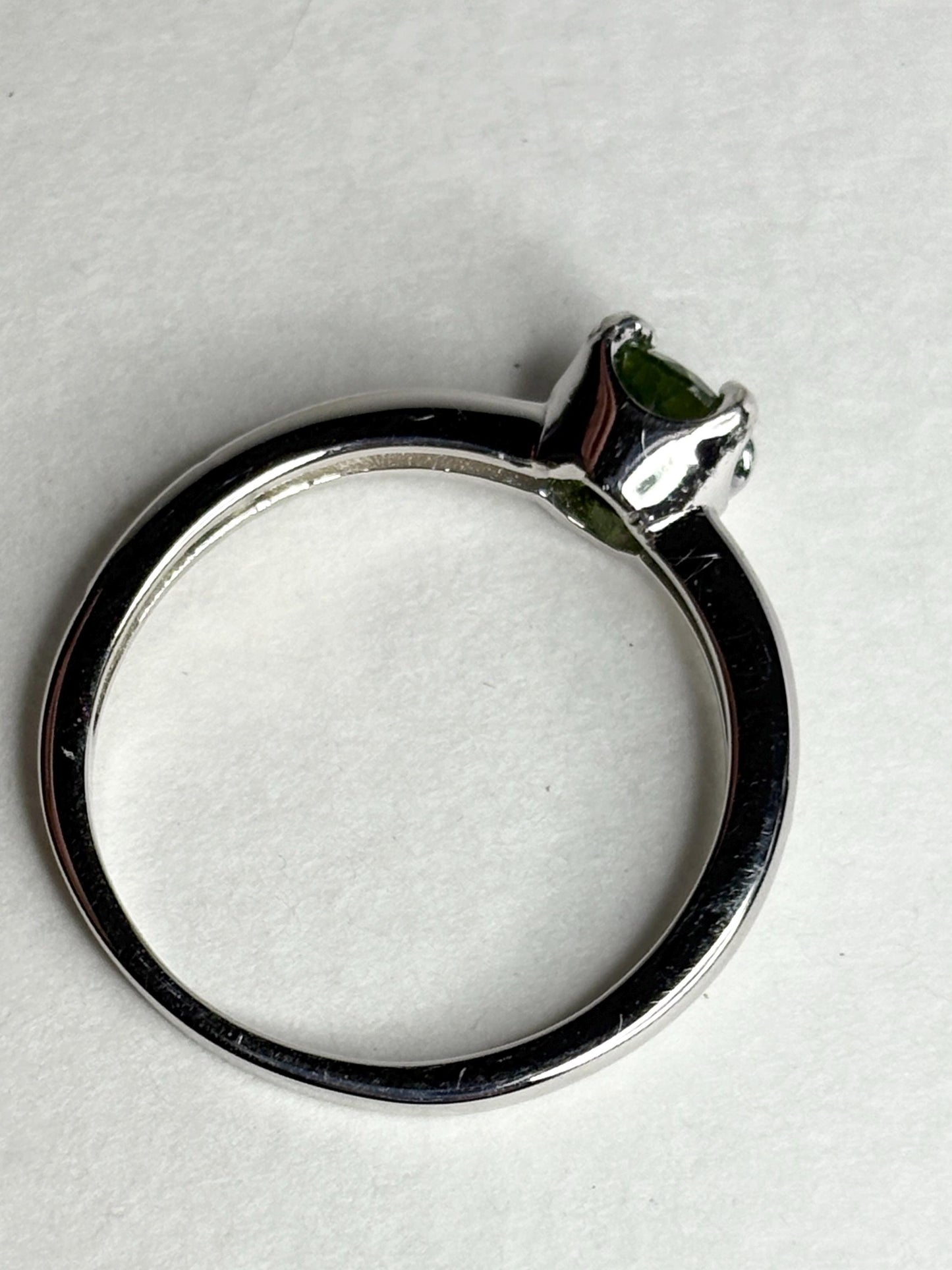 Sterling silver ring with a round green tourmaline gemstone.