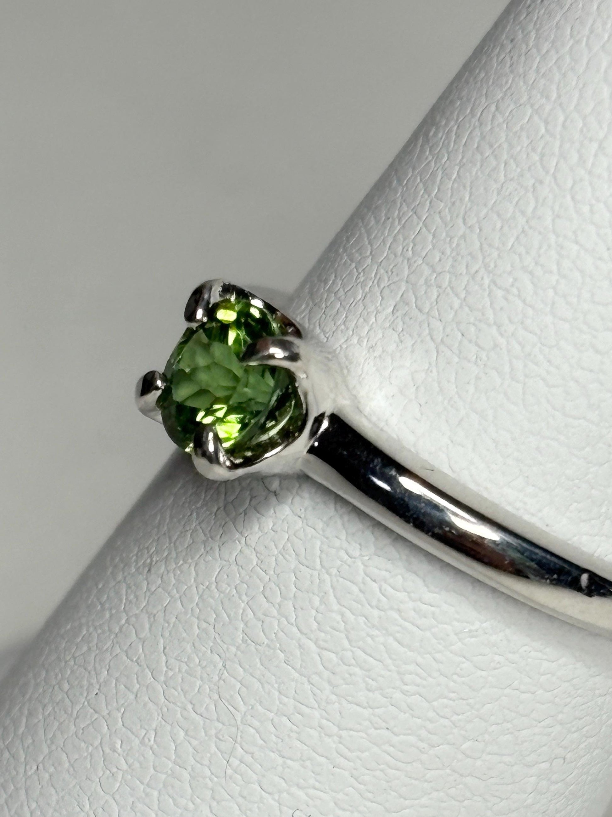 Sterling silver ring with a round green tourmaline gemstone.