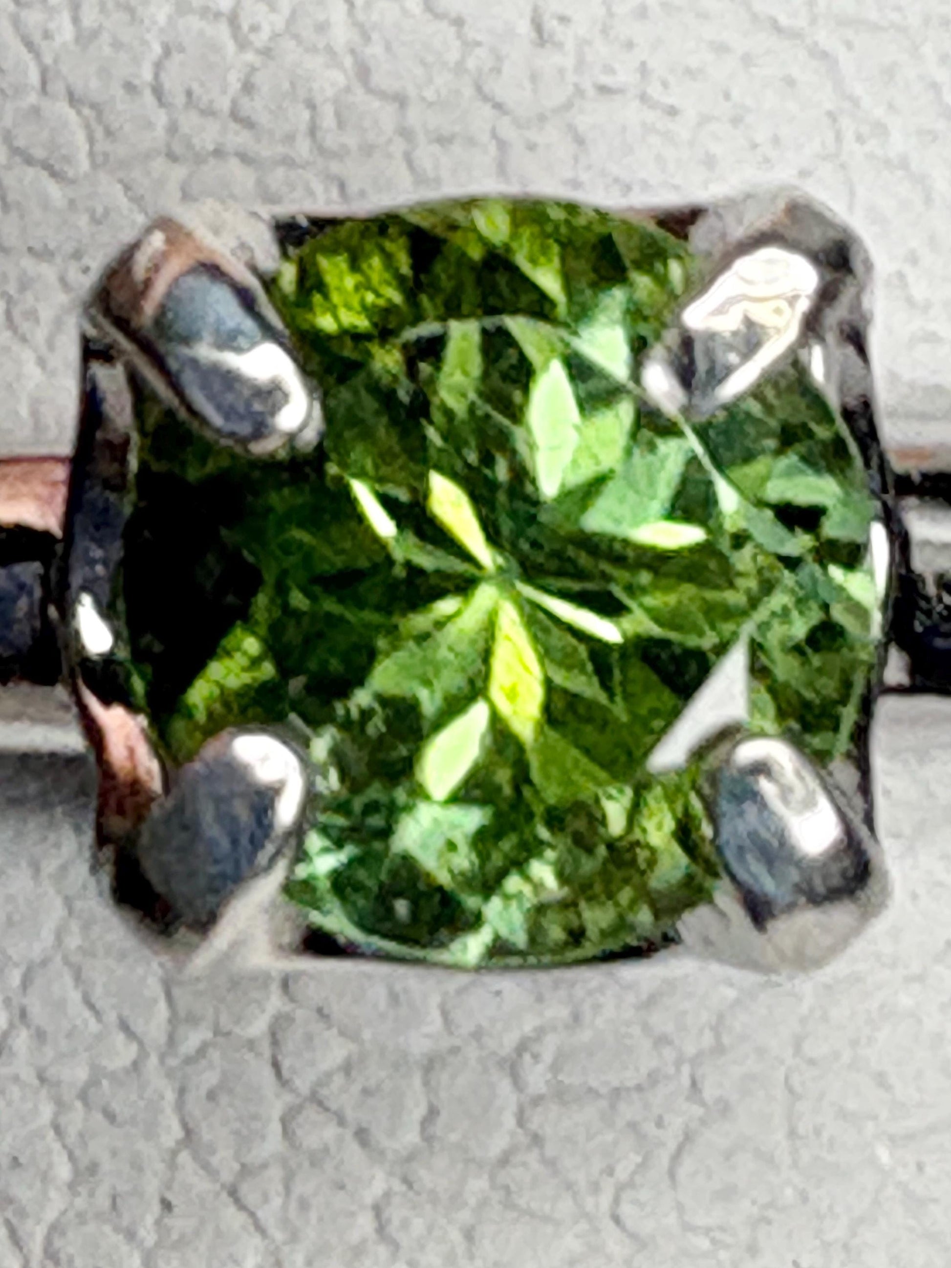 Sterling silver ring with a round, green tourmaline gemstone.