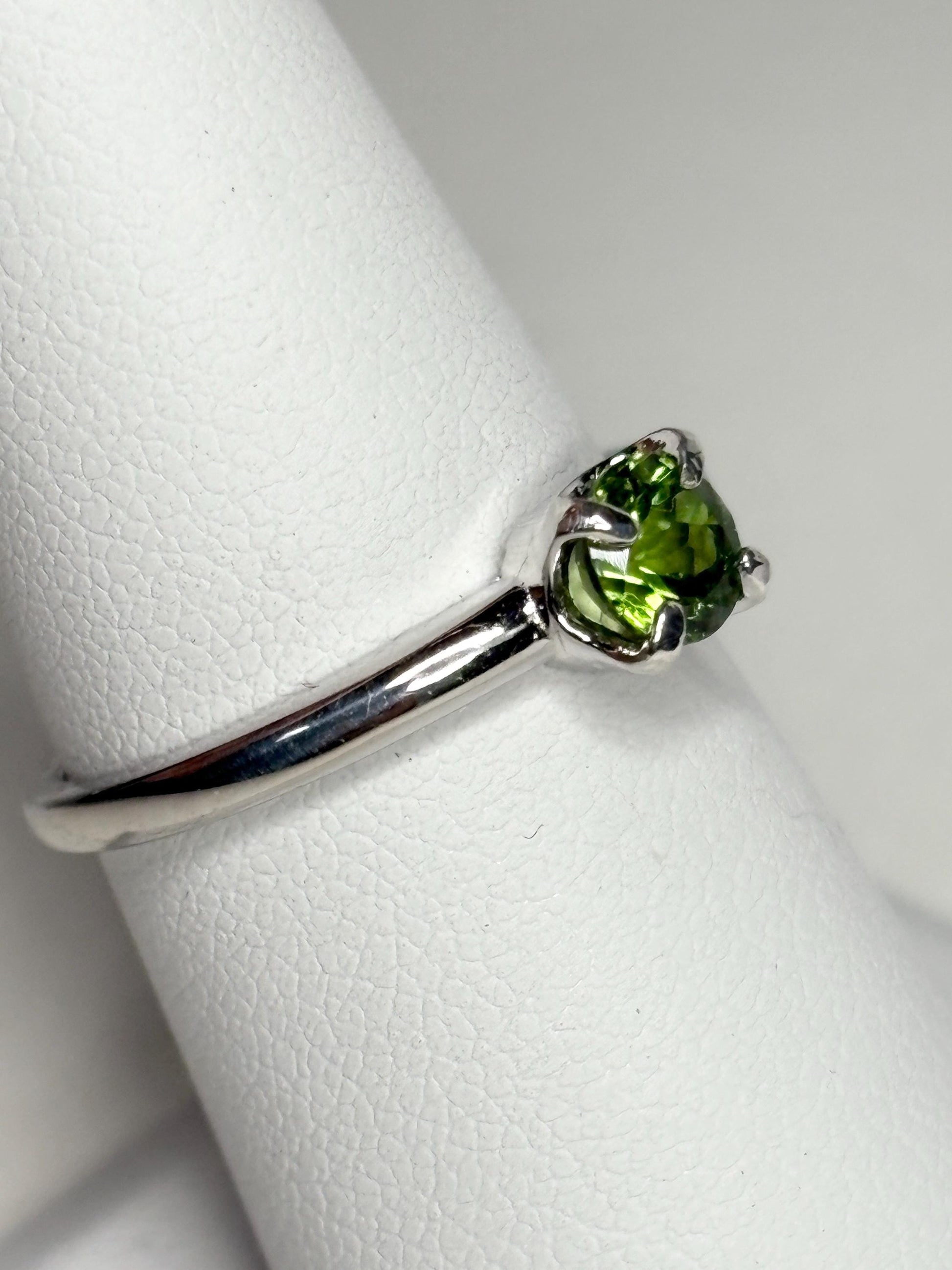 Sterling silver ring with a round, green tourmaline gemstone.