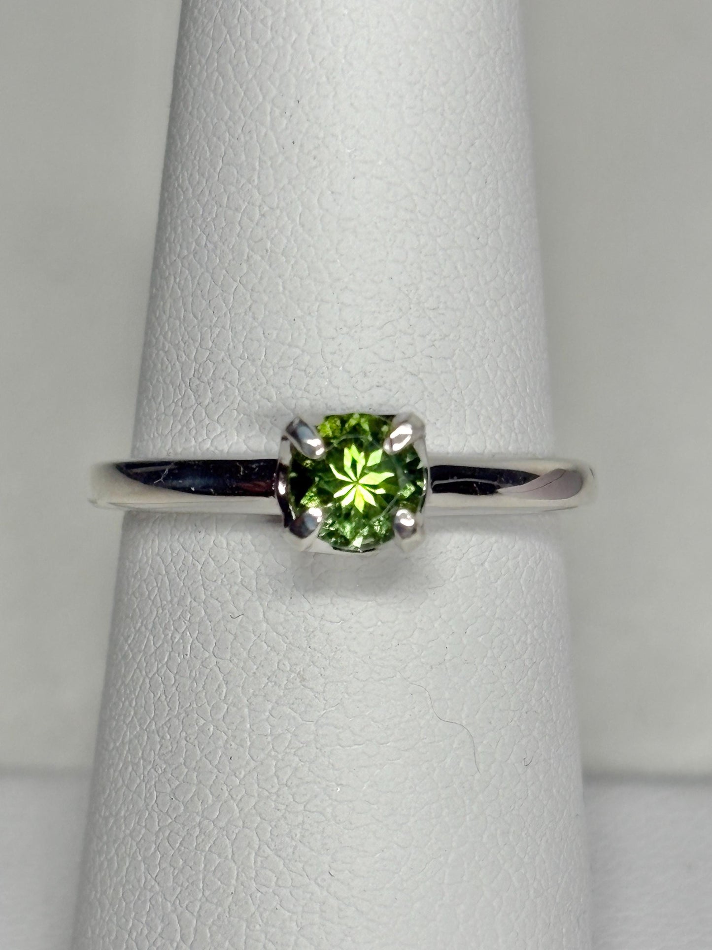 Sterling silver ring with a round, green tourmaline gemstone.
