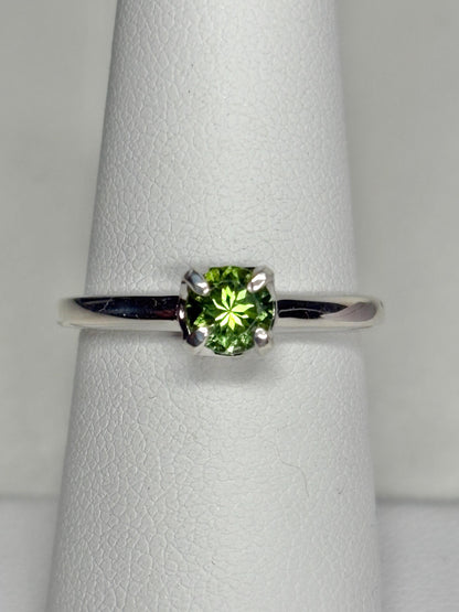 Sterling silver ring with a round, green tourmaline gemstone.