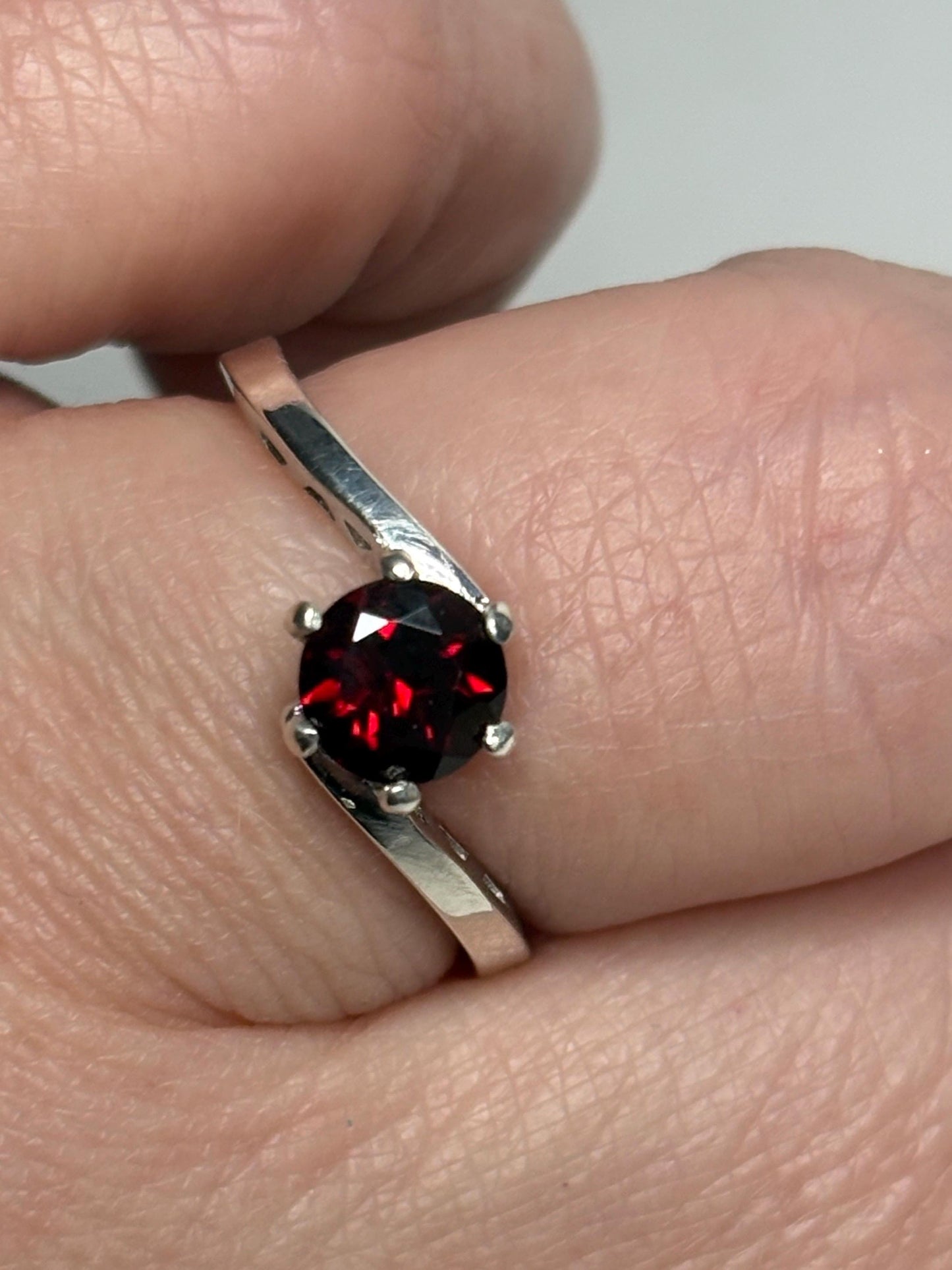 Sterling silver bypass ring with a round pyrope garnet.