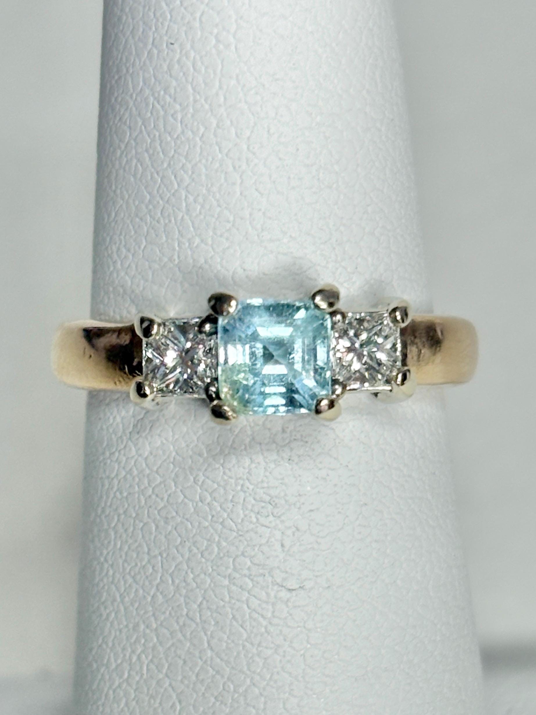 14k gold ring with a blue asscher cut tourmaline and two princess cut diamonds.