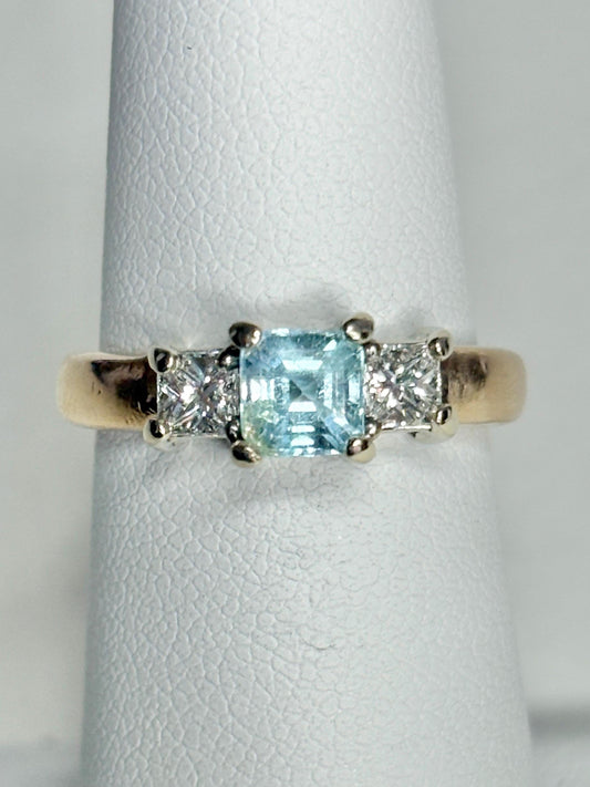 14k gold ring with a blue asscher cut tourmaline and two princess cut diamonds.