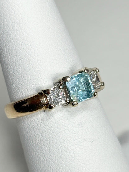 14k gold ring with a blue asscher cut tourmaline and two princess cut diamonds.