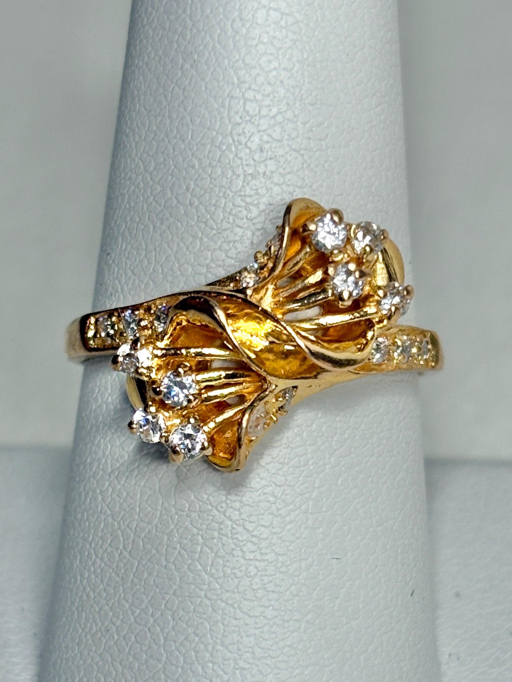 Solid 21k gold bypass ring with white stones.