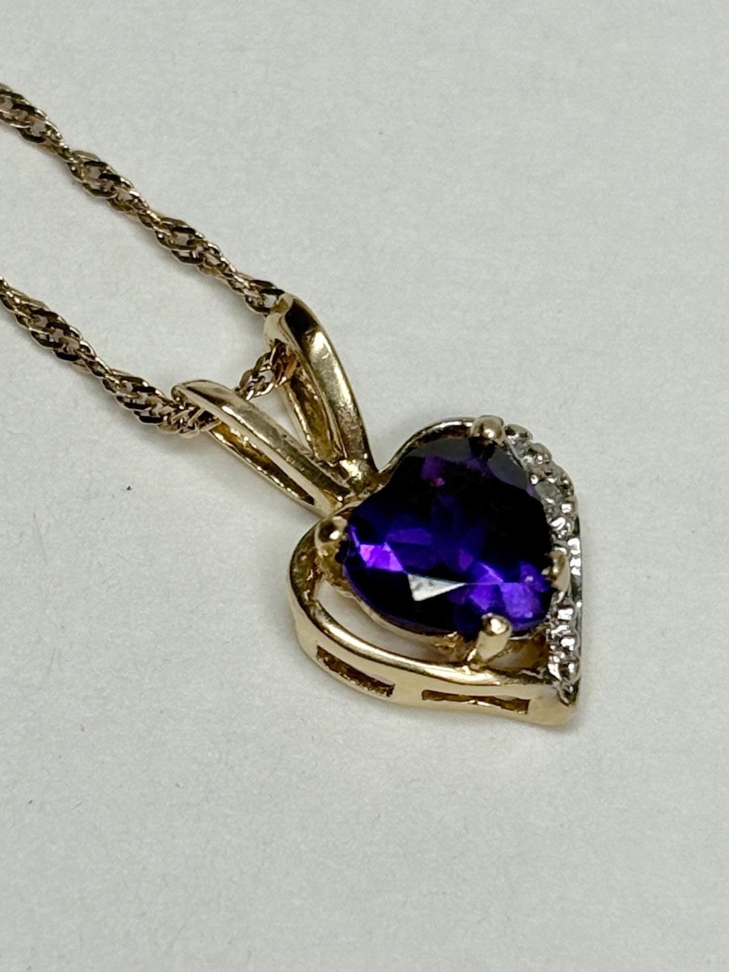 Heart-shaped amethyst and diamond pendant on a 14k gold chain.