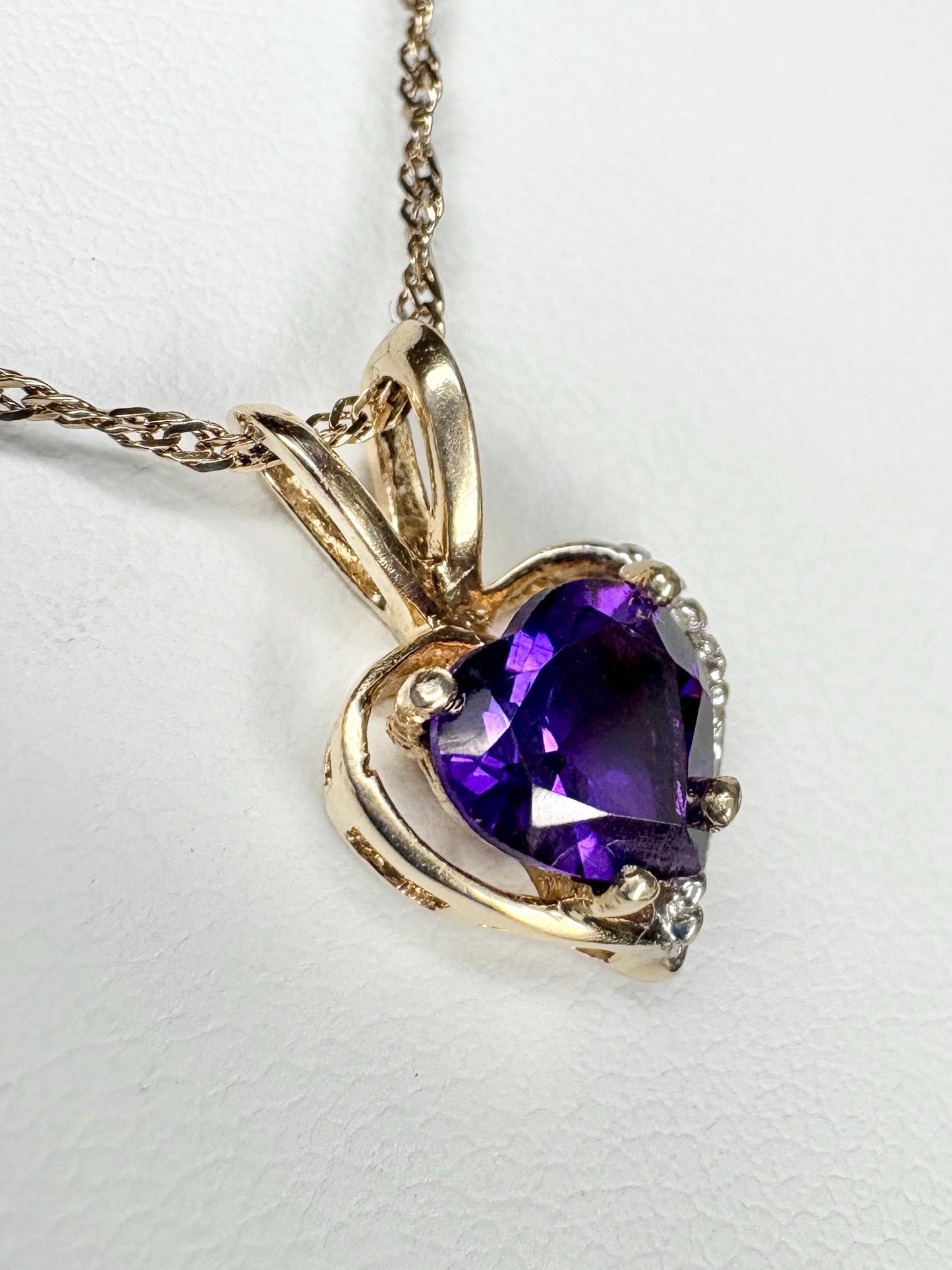 Heart-shaped amethyst and diamond pendant on a 14k gold chain.
