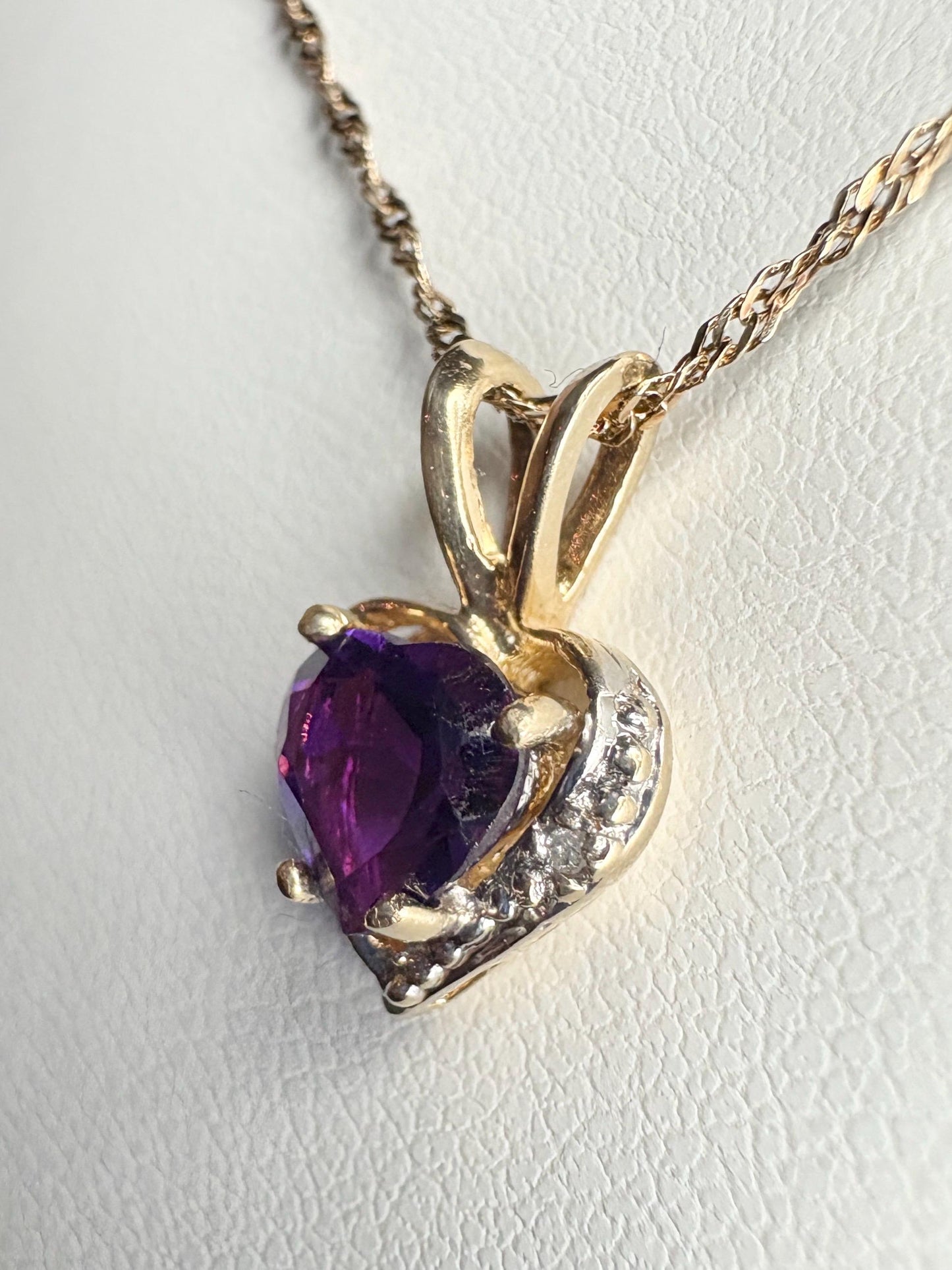 Heart-shaped amethyst and diamond pendant on a 14k gold rope chain.