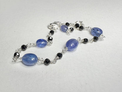 Sterling silver bracelet with oval tanzanite and faceted black diamond beads.