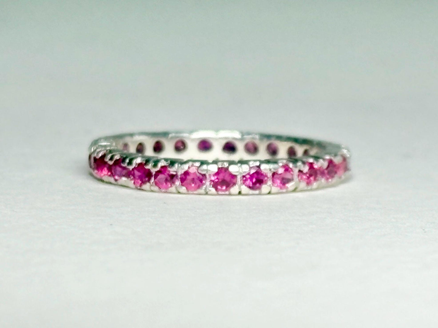 Hot pink sapphire eternity ring in sterling silver.