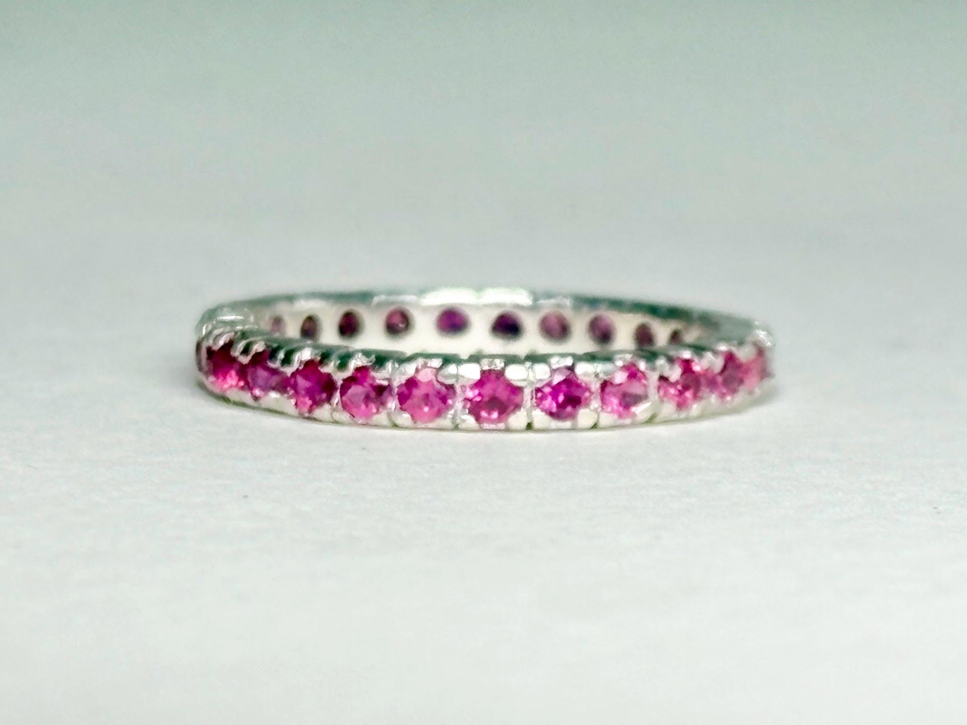 Hot pink sapphire eternity ring in sterling silver.