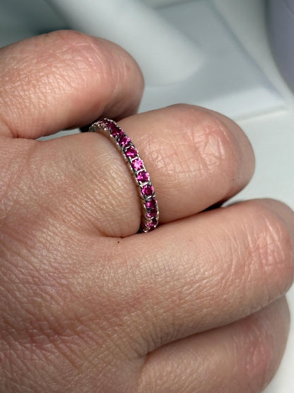 Hot pink lab-grown sapphire eternity ring in sterling silver.