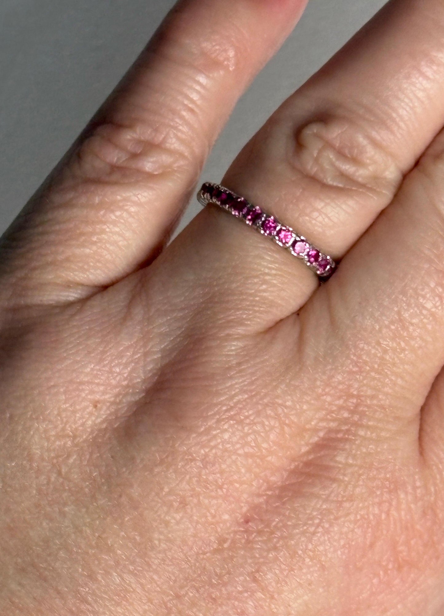 Hot pink lab-grown sapphire eternity ring in sterling silver.
