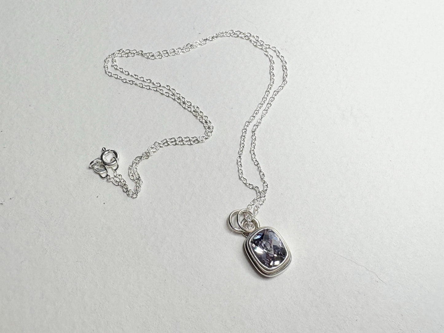 Sterling silver necklace with a lavender checkerboard faceted CZ solitaire pendant.