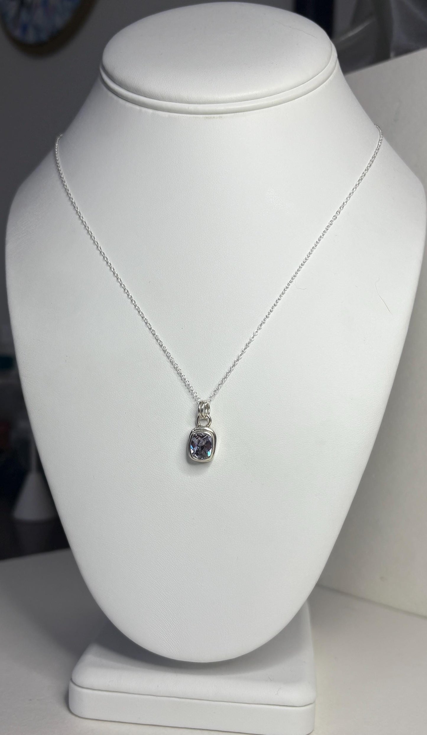 Sterling silver necklace with a bezel-set lavender checkerboard faceted CZ pendant.