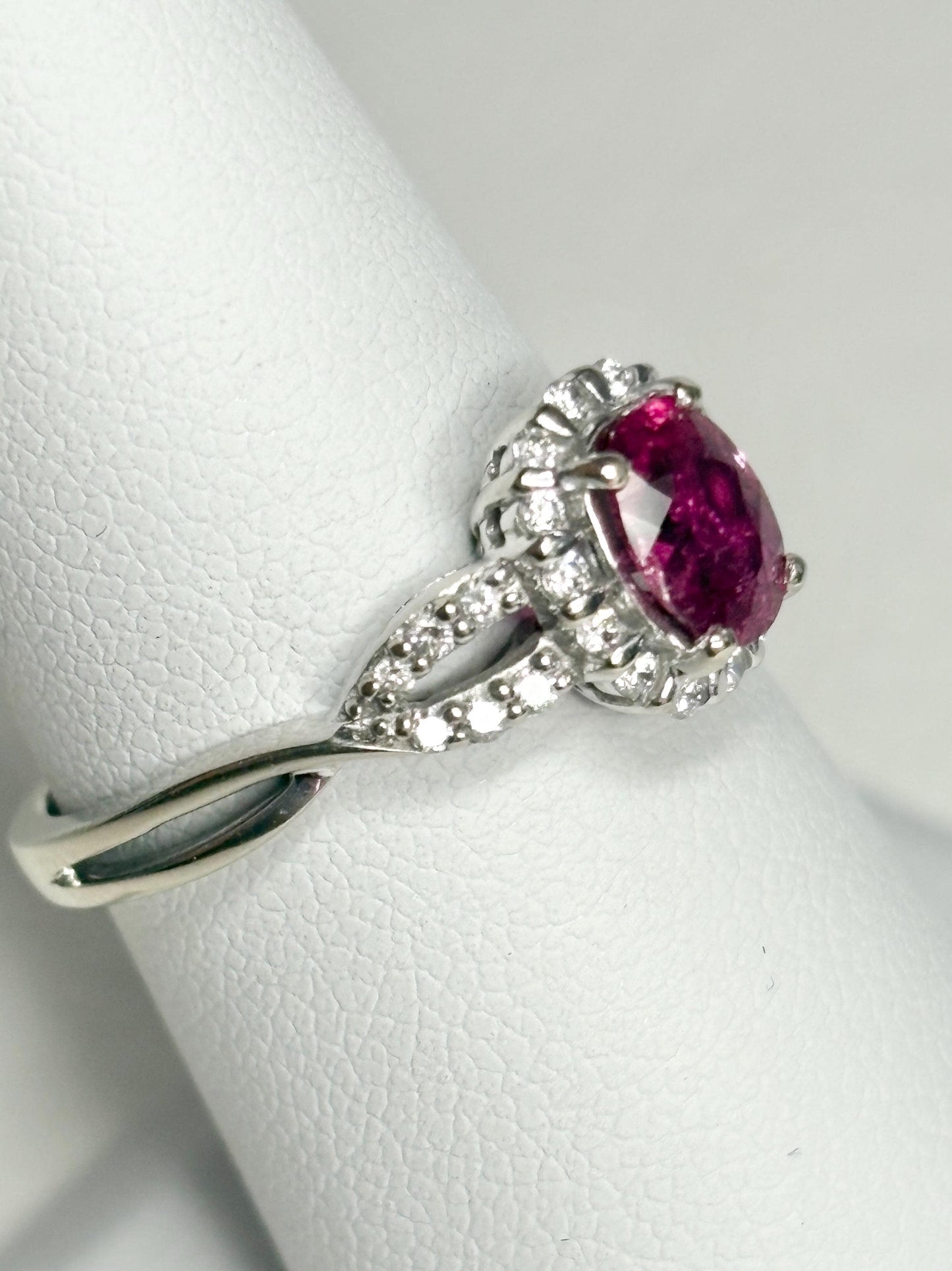 Oval rubellite tourmaline and diamond halo ring in 10k white gold.