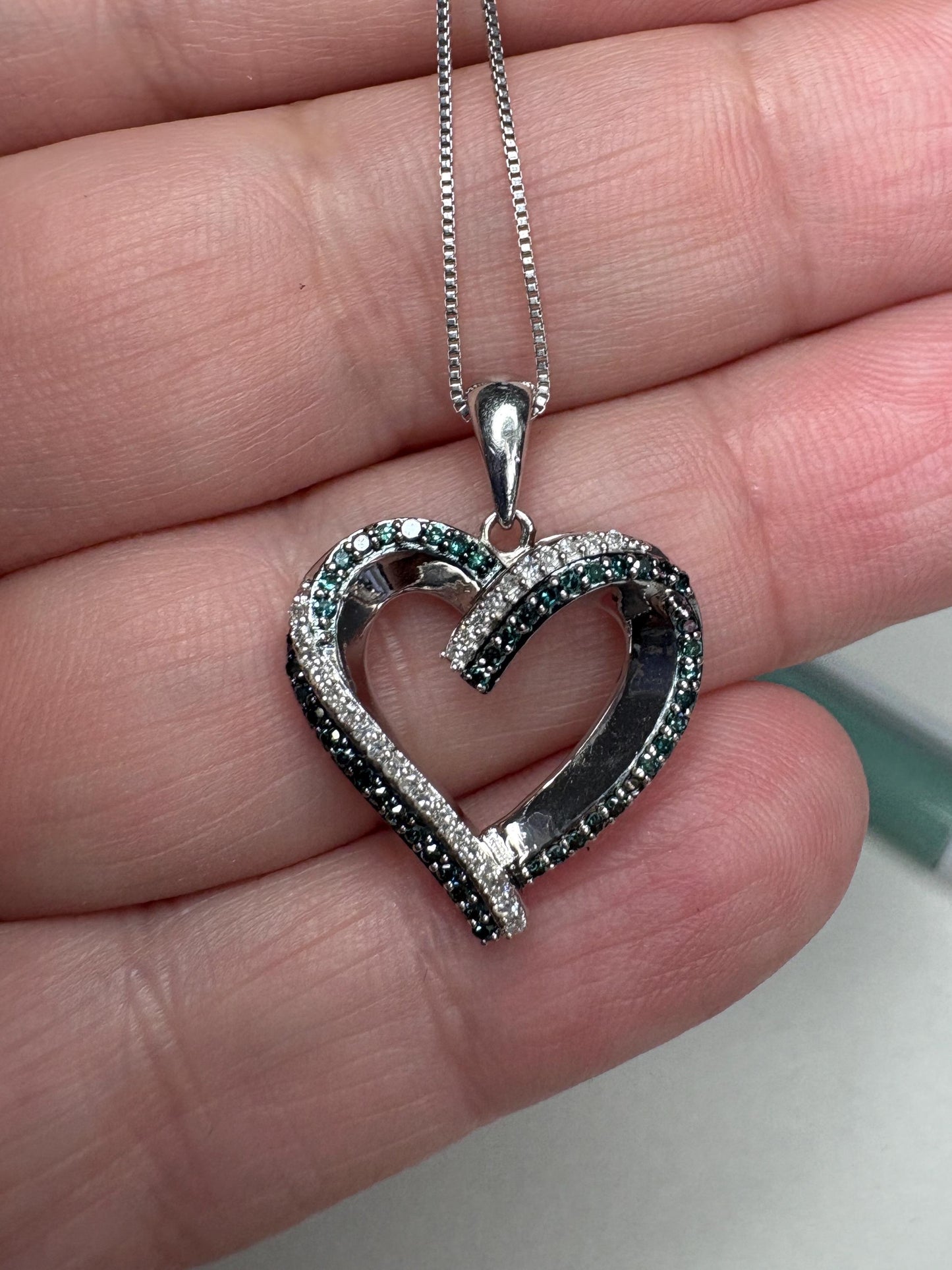 Sterling silver heart pendant necklace with blue and white diamonds.
