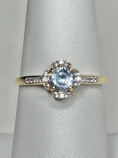 9k gold ring with a Montana sapphire and white zircon in a floral halo design.