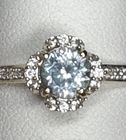 A 9k gold ring with a Montana sapphire and white zircon in a floral halo design.