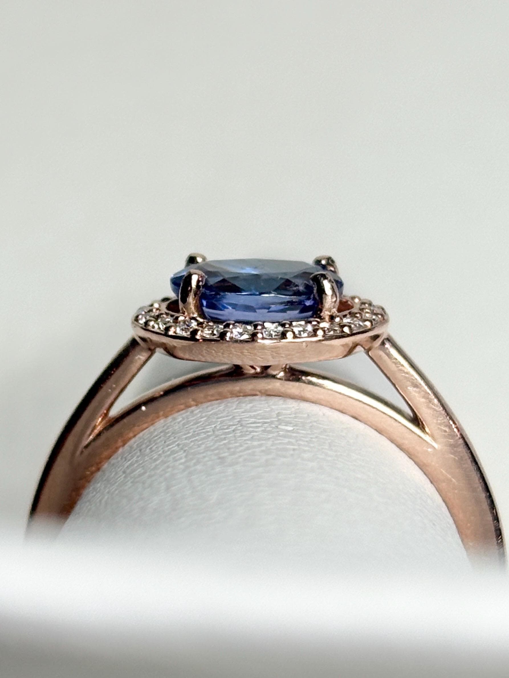 Rose gold ring with oval tanzanite and diamond halo.