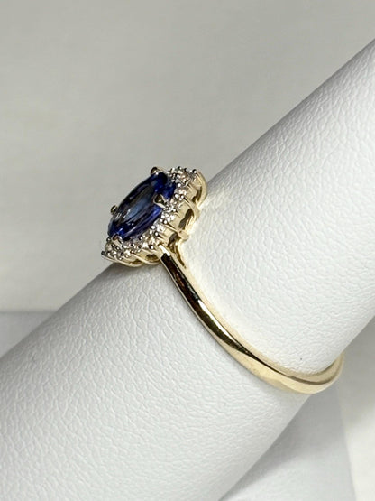 Oval tanzanite and zircon halo ring in 9k gold.