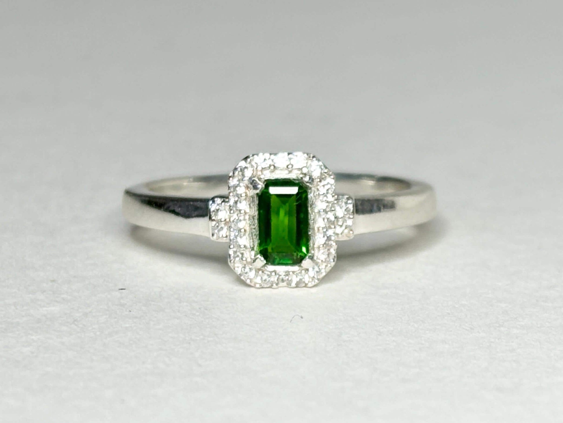 Sterling silver ring with emerald-cut chrome diopside and zircon halo.