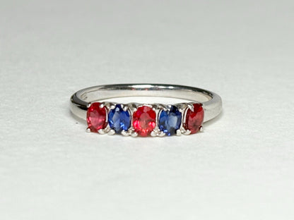 Sterling silver band ring with alternating oval red and blue sapphires.
