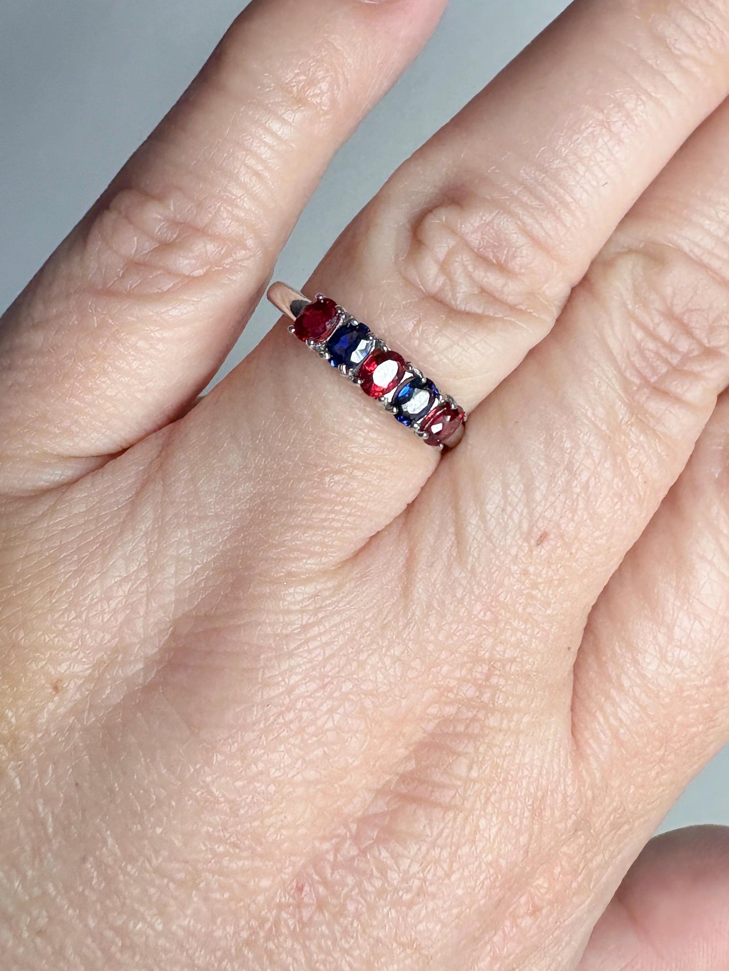 Sterling silver band ring with oval red and blue sapphires.