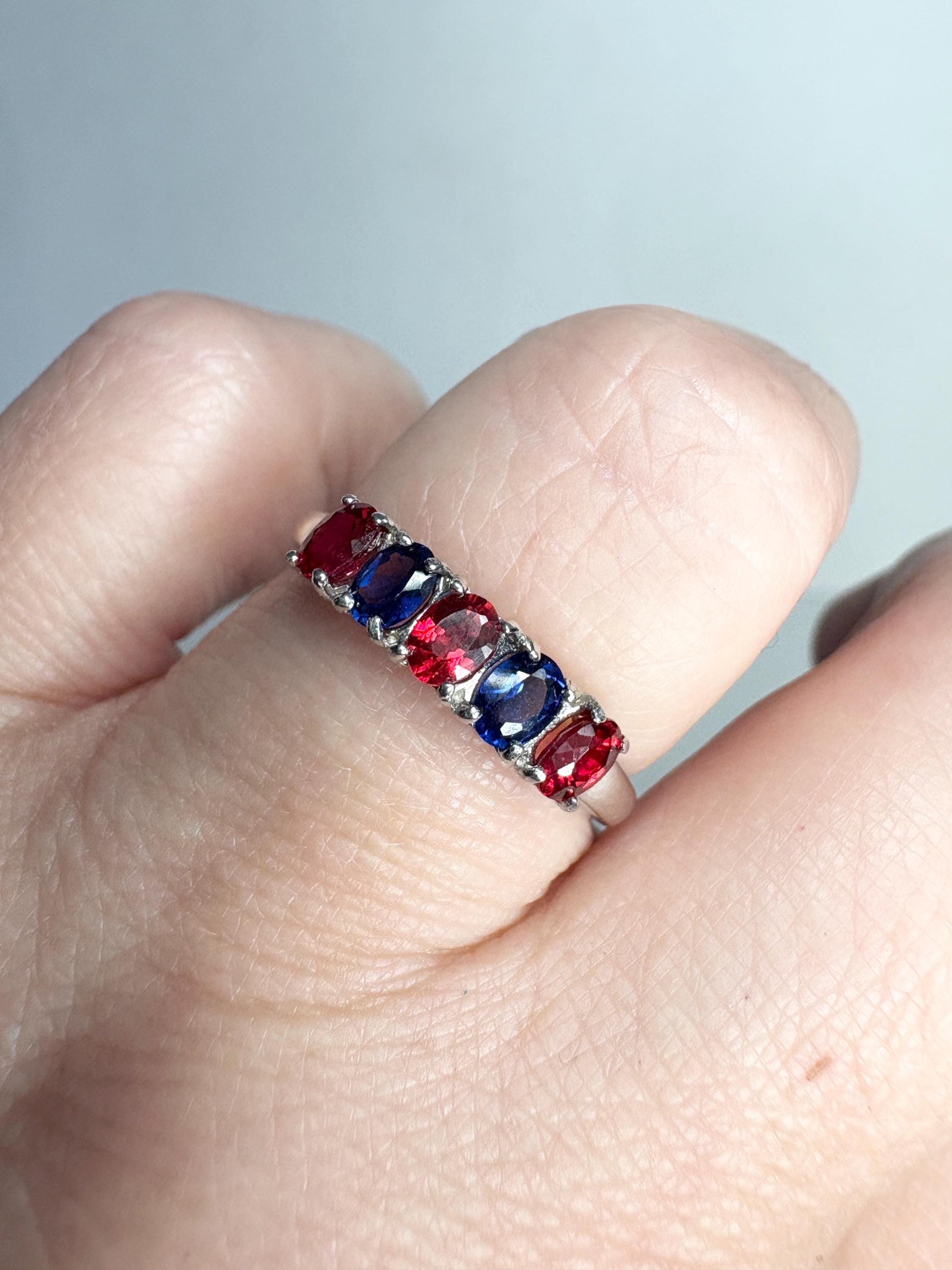 Sterling silver band ring with oval red and blue sapphires.