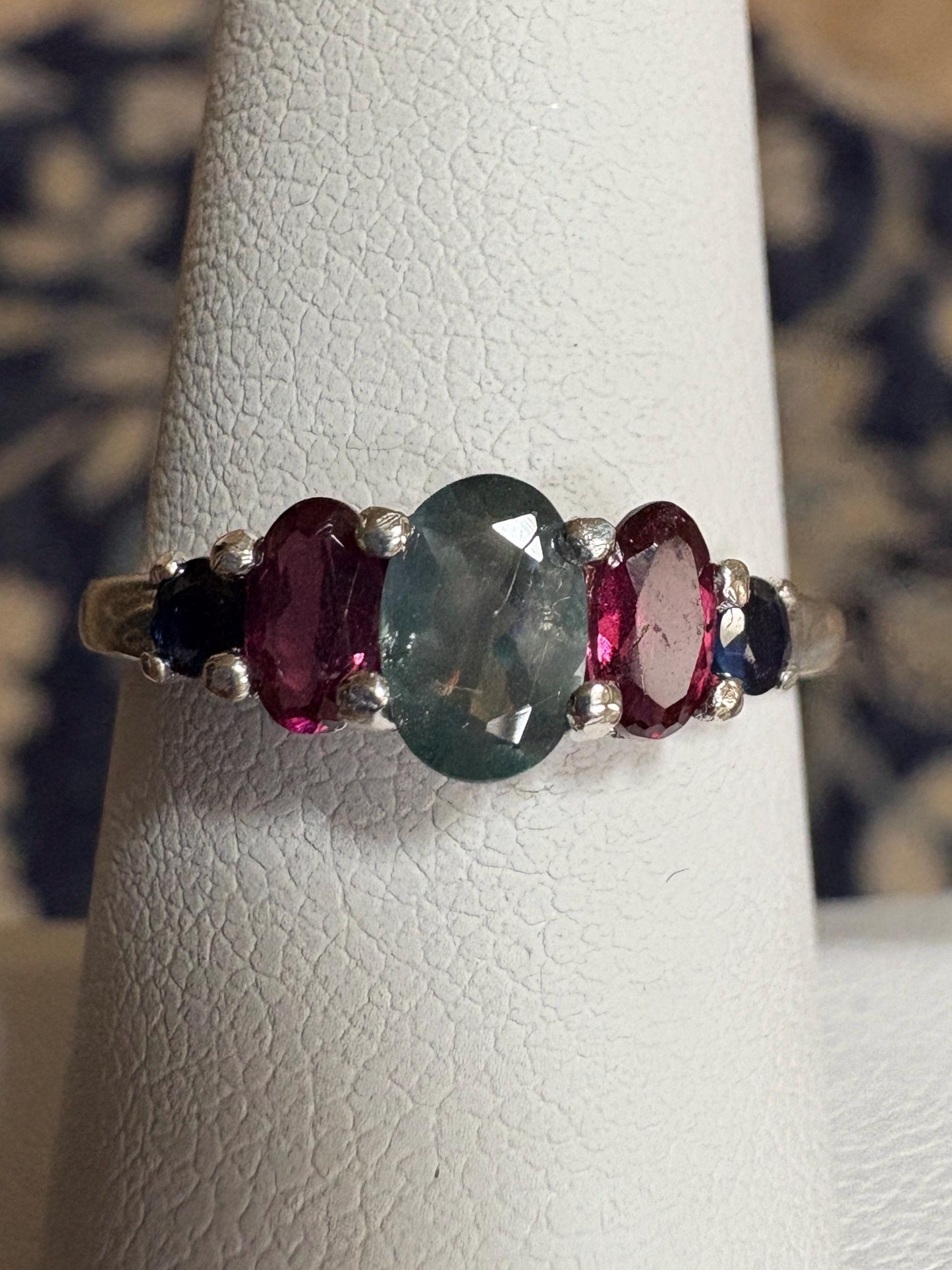 Sterling silver band ring with oval alexandrite, rhodolite garnets, and blue sapphires.