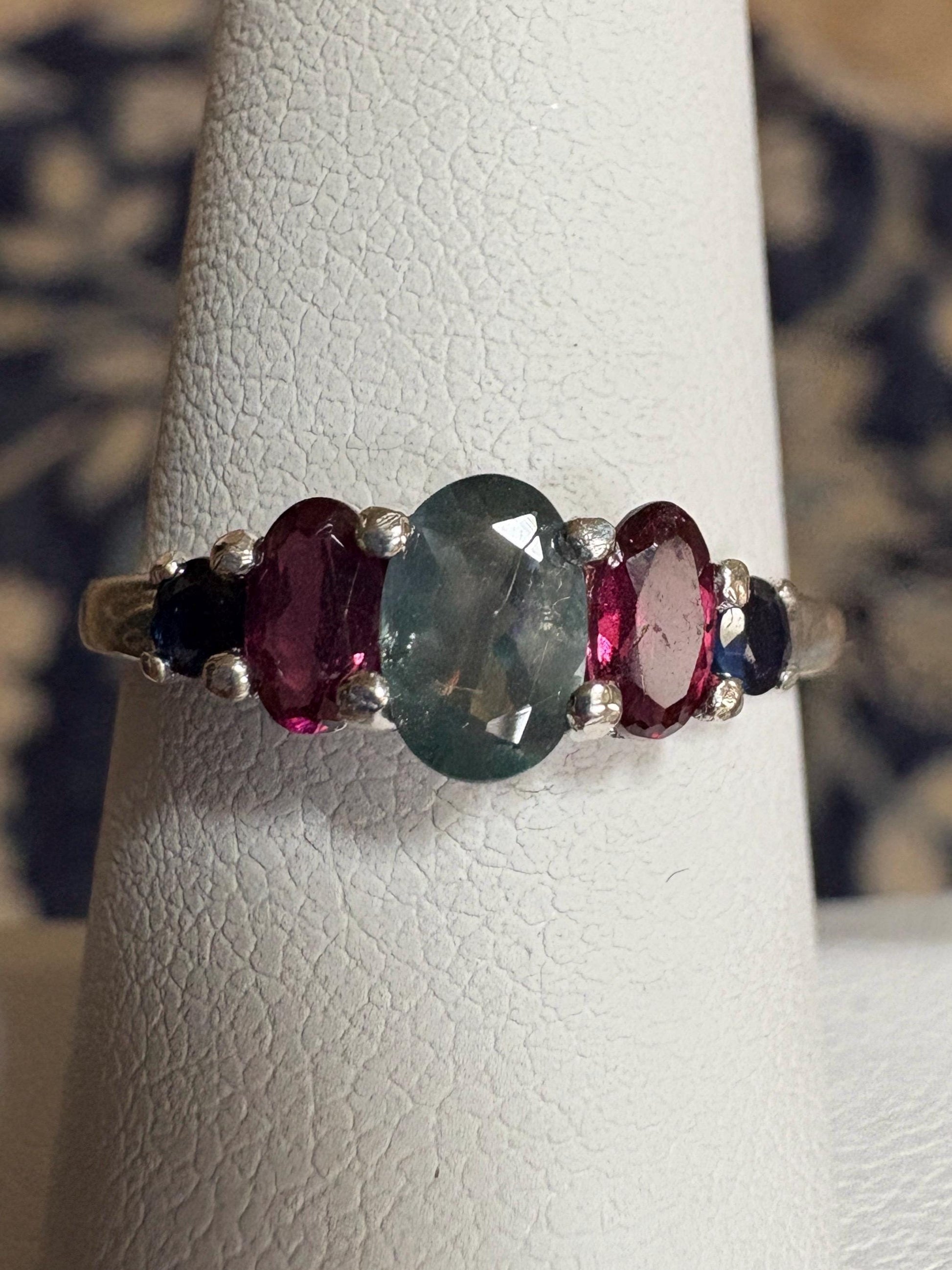 Sterling silver band ring with oval alexandrite, rhodolite garnets, and blue sapphires.