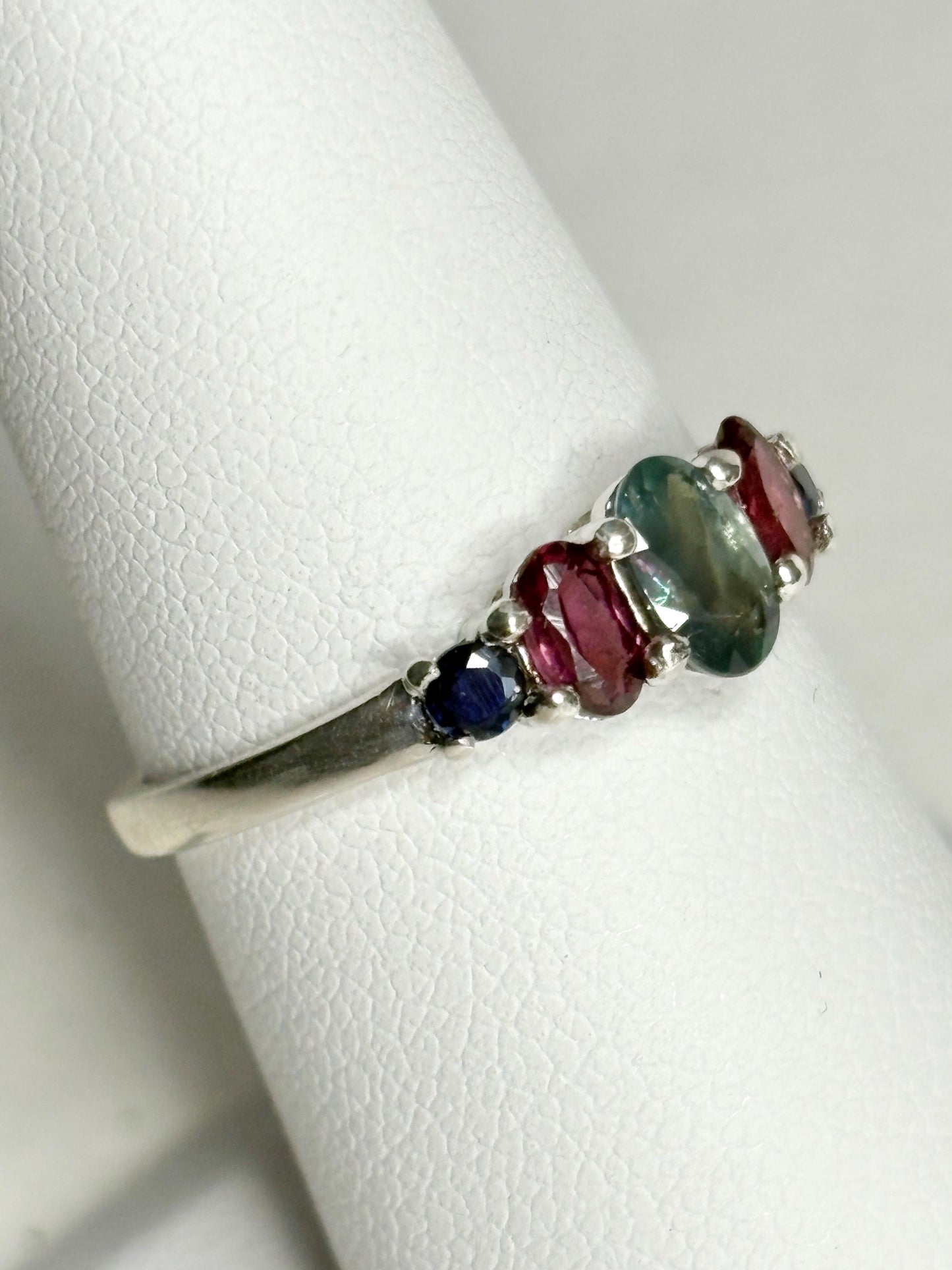 Sterling silver band ring with oval alexandrite, rhodolite garnets, and blue sapphires.