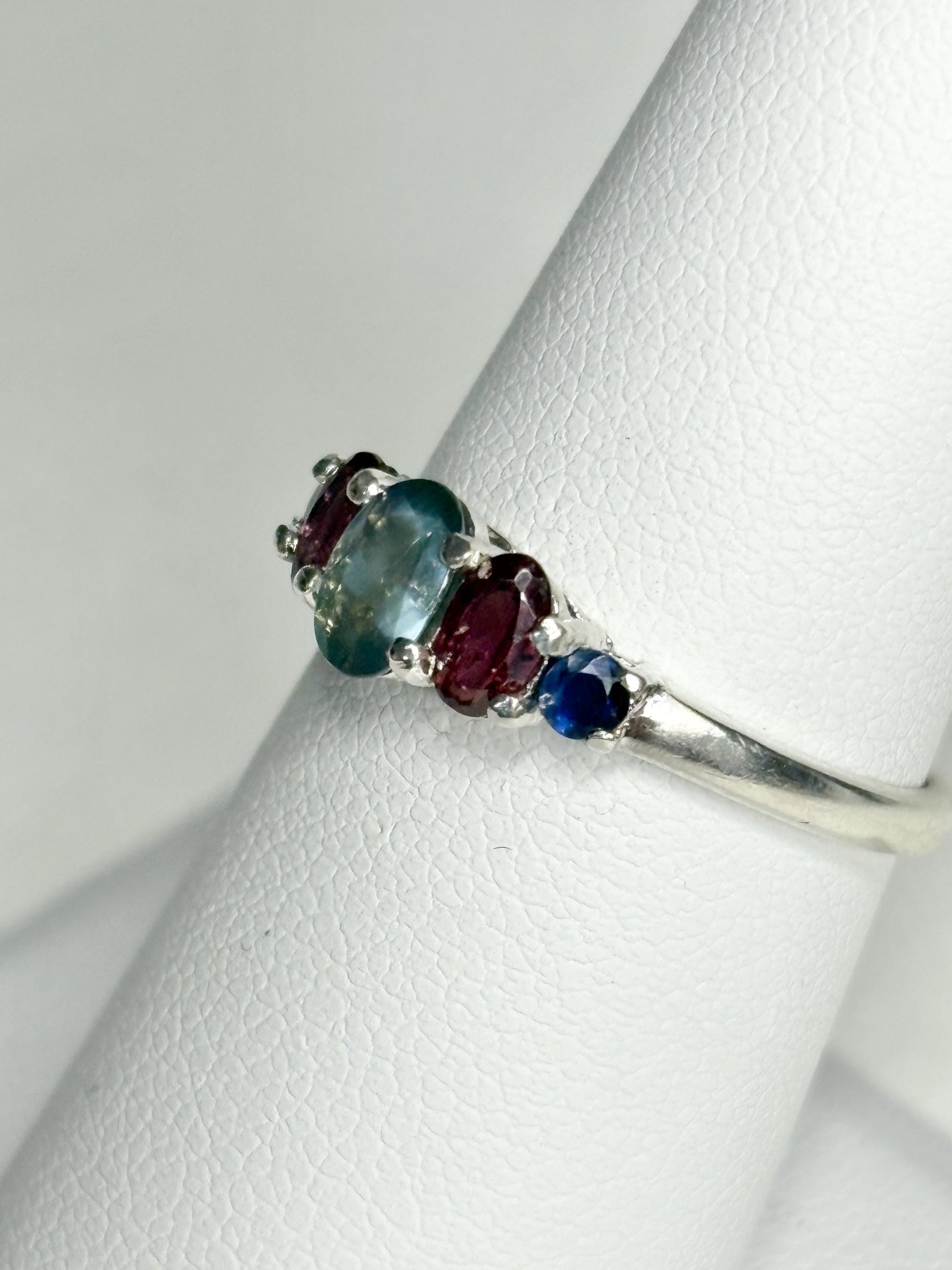 Sterling silver band ring with oval alexandrite, rhodolite garnets, and blue sapphires.