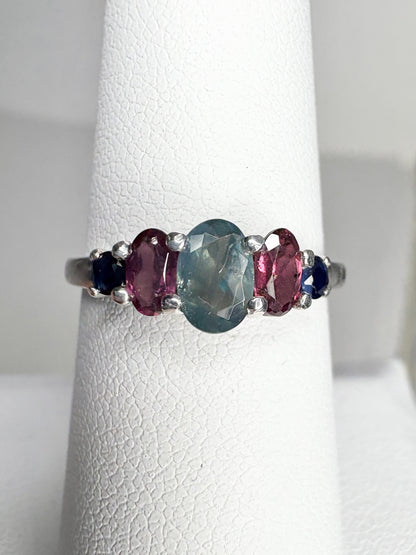 Sterling silver band ring with a central oval alexandrite and flanking rhodolite garnets and blue sapphires.