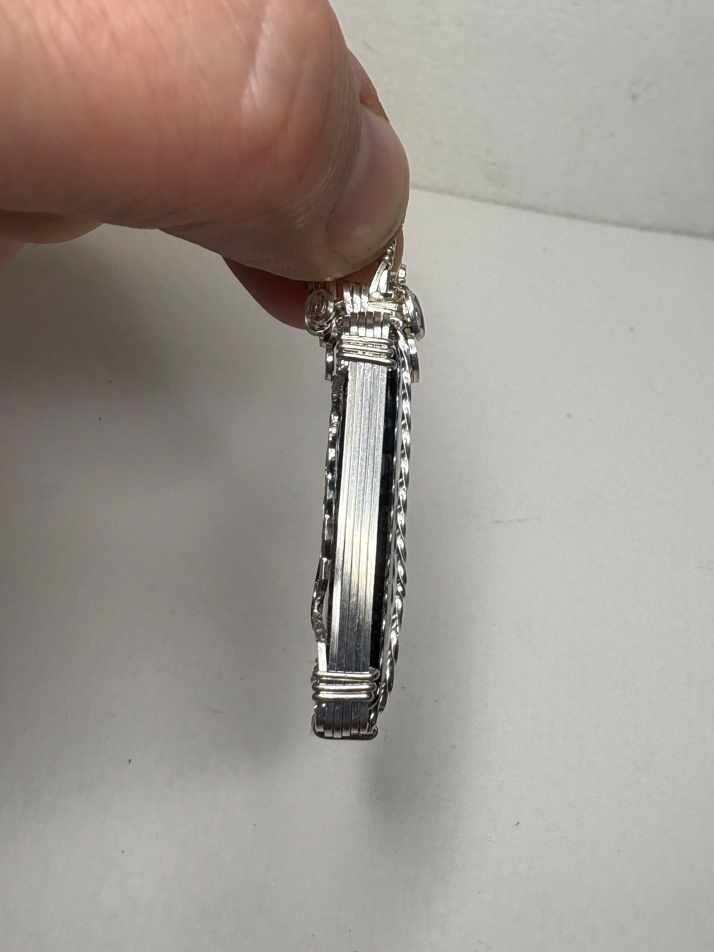 Sterling silver wire-wrapped pendant featuring a rectangular covellite stone.