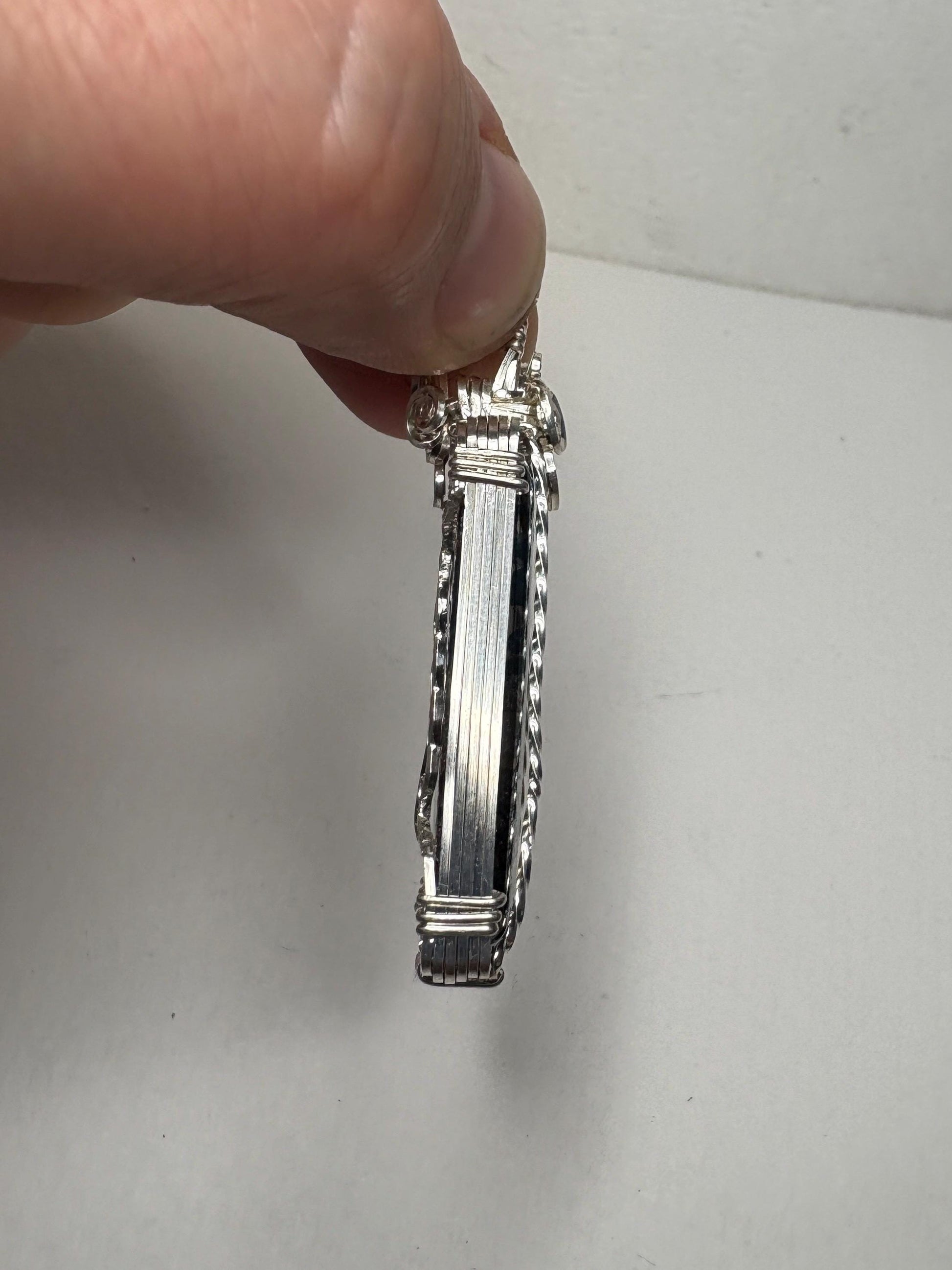 Sterling silver wire-wrapped pendant featuring a rectangular covellite stone.