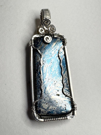 Wire wrapped sterling silver pendant featuring a rectangular covellite stone with blue and silver metallic luster.