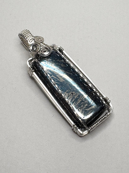 Sterling silver wire-wrapped pendant featuring a rectangular covellite stone with metallic blue and gold hues.