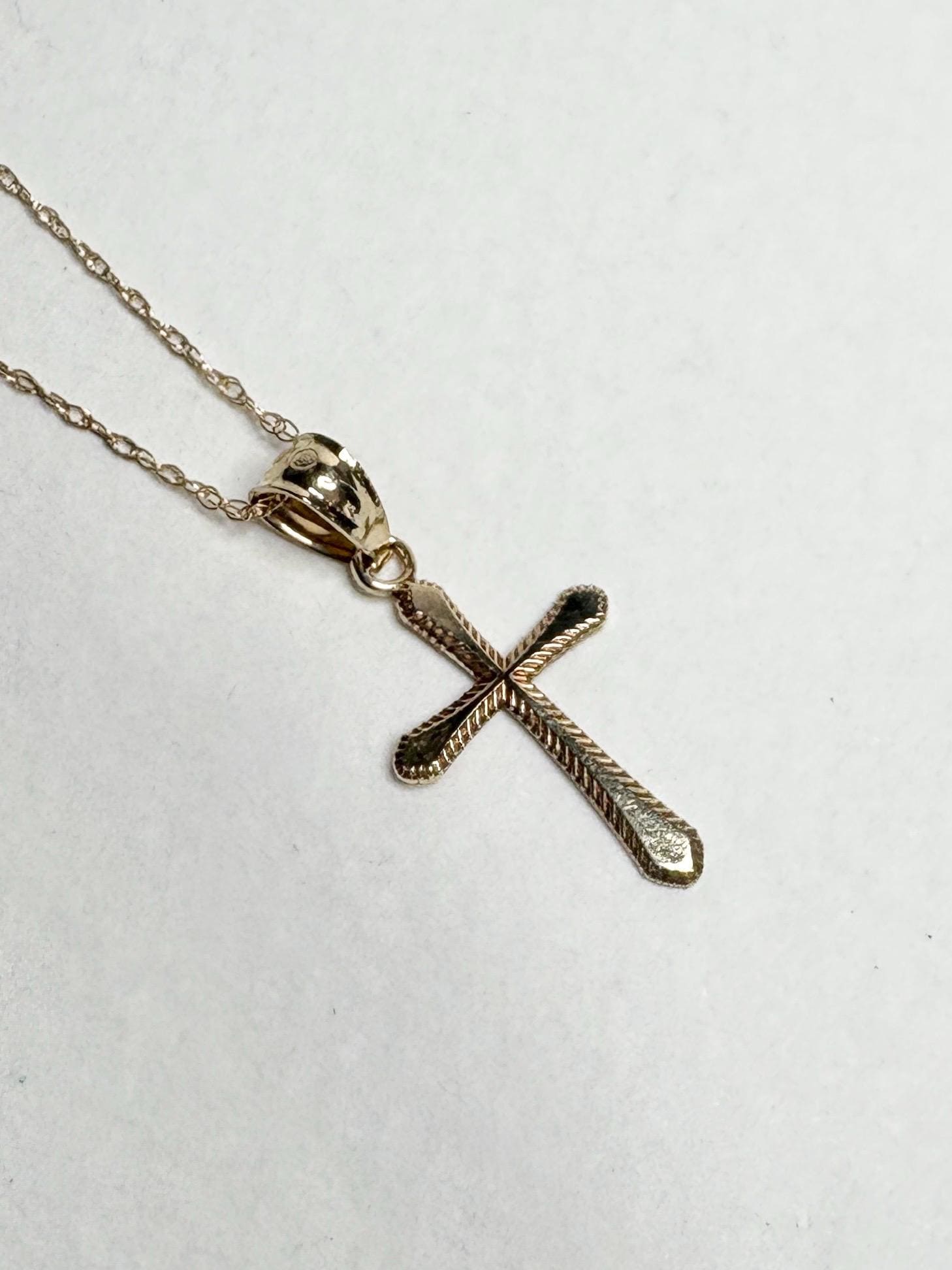 Solid 10k gold cross pendant necklace with a fine rope chain.