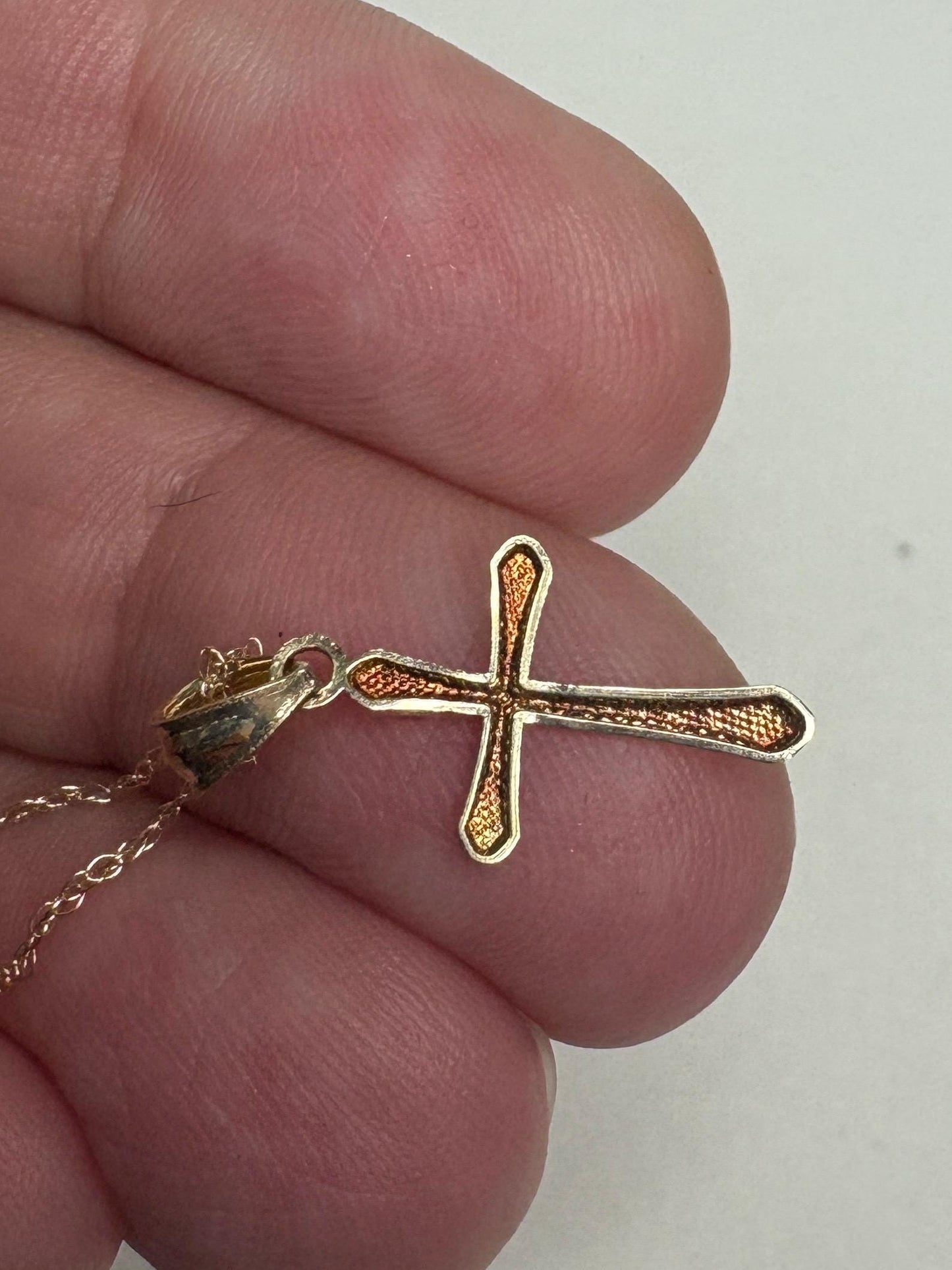 Solid 10k gold cross pendant necklace with a fine rope chain.